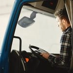 Mains d'un chauffeur sur le volant d'un camion